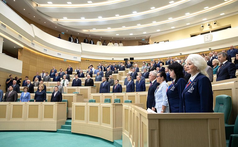 Сенаторы исполняют гимн России перед началом 437-го заседания Совета Федерации